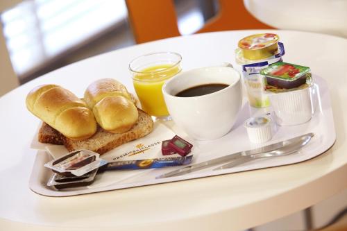 - un plateau de petit-déjeuner avec du pain et du café sur une table dans l'établissement Premiere Classe Lille - Villeneuve d’Ascq - Stade Pierre Mauroy, à Lezennes