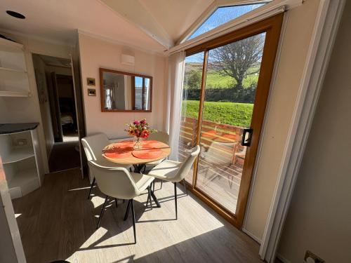 a dining room with a table and chairs and a balcony at Cosy Caravan by the sea in Cairnryan