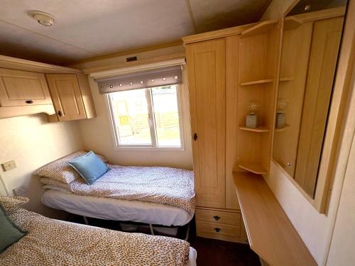 a small room with two beds and a window at Cosy Caravan by the sea in Cairnryan
