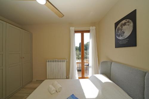 a bedroom with a bed and a window at Olive Garden Garda - pool & view in Moniga
