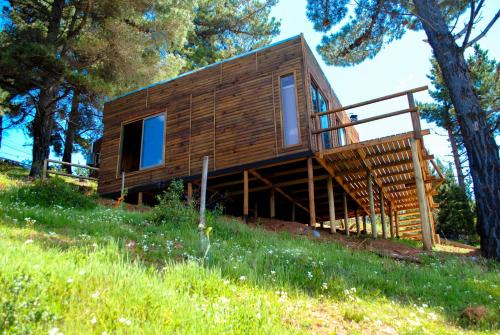 a wooden house on a hill with trees at Cabañas & SPA Carilafquen in Laguna Verde