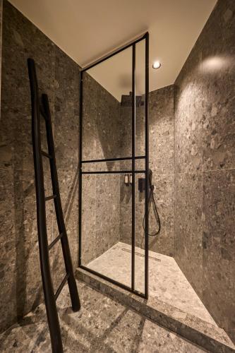 a bathroom with a shower with a glass door at Mamy Blue Slow Living in Athens