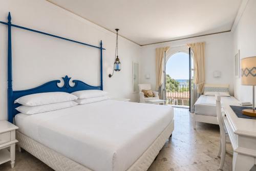 a bedroom with a large white bed and a desk at Phi Hotel Sighientu in Capitana