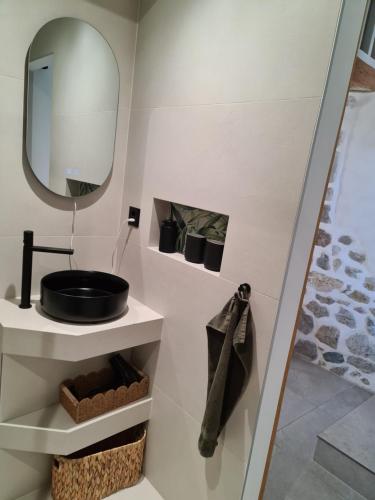 a bathroom with a sink and a mirror at Au petit nid in Vilars