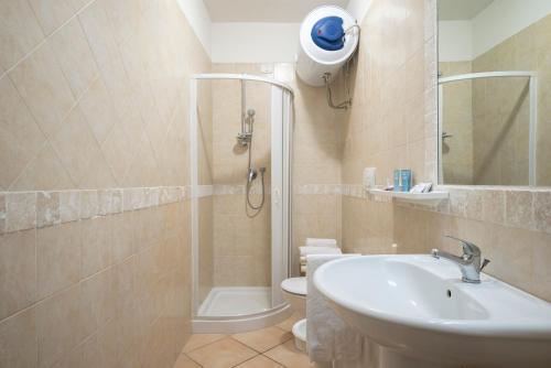 a bathroom with a shower and a sink and a toilet at Appartamenti La Vecchia Posta - 50 mt dal Mare in Marina di Grosseto