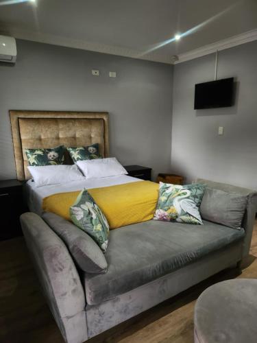 a bed with a yellow blanket on a couch at Ntobongwana in Pinetown
