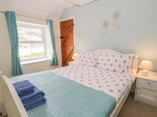 a bedroom with a bed and a window at Ysgoldy in Dolwyddelan