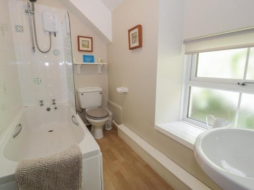 a bathroom with a tub and a toilet and a sink at Ysgoldy in Dolwyddelan