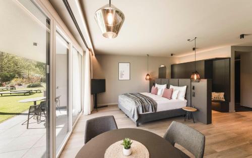 a bedroom with a bed and a table and chairs at Belia Lofts - ADULTS ONLY - Apartments in Appiano sulla Strada del Vino
