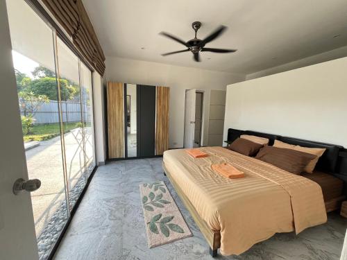 a bedroom with a bed and a ceiling fan at Maprao Villa in Mae Nam