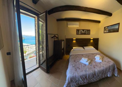 a bedroom with a bed with a view of the ocean at B&B La Bastia in Scilla