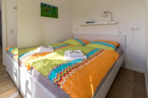 a bed with colorful sheets and shoes on it at Ferienwohnung-in-Luebesse in Lübesse