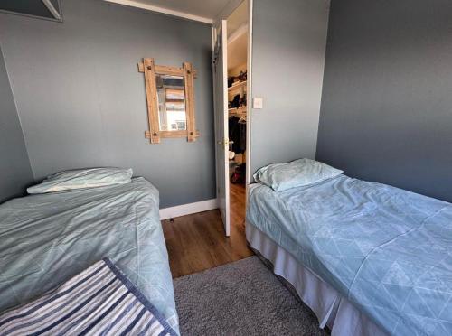 a bedroom with two beds and a closet at 2 Bedroom - Seaside Apartment in Dawlish Warren