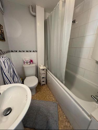 a bathroom with a sink and a toilet and a tub at 2 Bedroom - Seaside Apartment in Dawlish Warren
