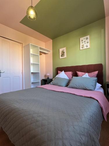 a bedroom with a large bed with pink and blue pillows at Résidences Les Murots 1 in Saint-André-les-Vergers