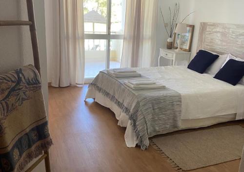 a bedroom with a large bed and a window at Troia Apartments in Troia