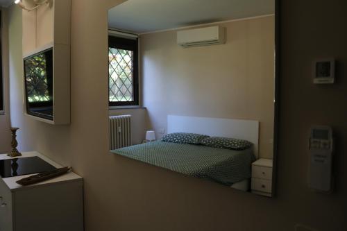 a reflection of a bedroom with a bed in a mirror at Tevere 20 House in Monza