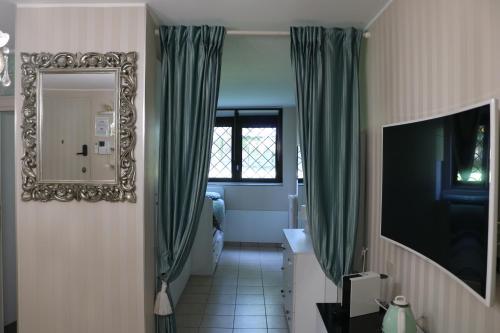 a hallway with green curtains and a mirror at Tevere 20 House in Monza