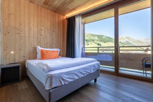 a bedroom with a bed and a large window at Montivas Lodge in Livigno
