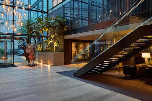 a lobby with a staircase in a building at The Edwardian Manchester, A Radisson Collection Hotel in Manchester