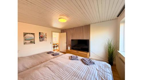 a bedroom with a large bed and a flat screen tv at Holeby Apartment 2 - next to Femern Puttgarden Lalandia Knuthenborg in Holeby