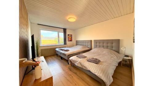 a bedroom with two beds and a window at Holeby Apartment 2 - next to Femern Puttgarden Lalandia Knuthenborg in Holeby
