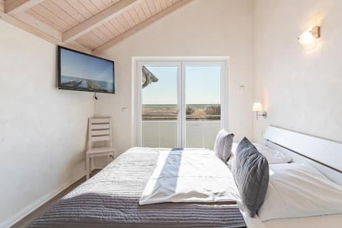a bedroom with a large bed and a window at Ferienhaus Kampfläufer in Dagebüll