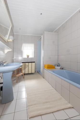 a bathroom with a tub and a sink at Ferienhaus-Weinmeyer in Paasdorf