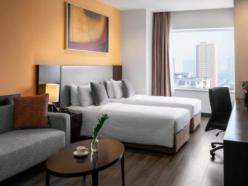 a hotel room with a bed and a couch at Somerset Hoa Binh Hanoi in Hanoi