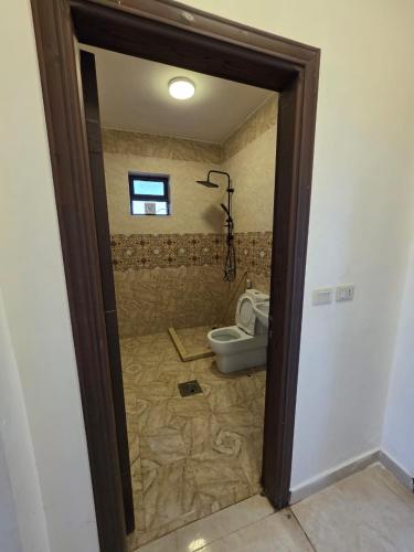 a bathroom with a toilet in a room at Green view in Al Mazār