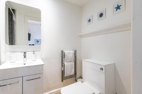 a bathroom with a toilet and a sink and a mirror at The Dunes - Room 12 in Rhosneigr