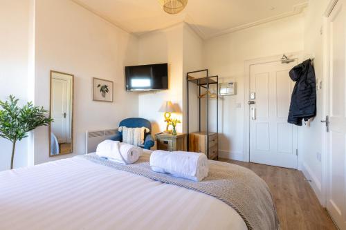 a bedroom with a large bed with two towels at The Dunes - Room 12 in Rhosneigr