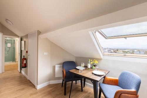 a dining room with a table and chairs and a window at The Wave - Room 15 in Rhosneigr