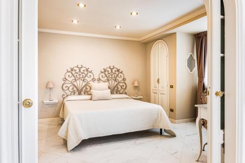 a bedroom with a white bed with a ornate headboard at Casa OliVera in Viareggio