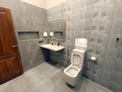 a bathroom with a toilet and a sink at The Ceylon Slate in Tangalle