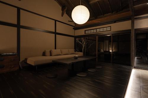 a bedroom with a bed and a table and a lamp at MUSUBI Hakone in Sengokuhara