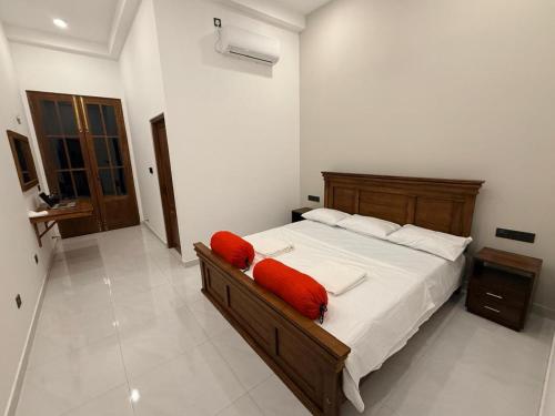 a bedroom with a bed with red pillows on it at The Ceylon Slate in Tangalle