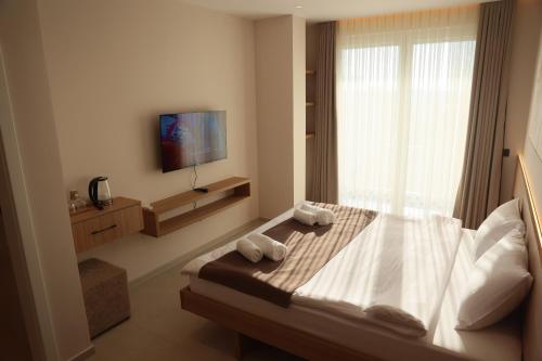 a bedroom with a bed with two towels on it at Hotel & Restaurant HAREA in Suharekë