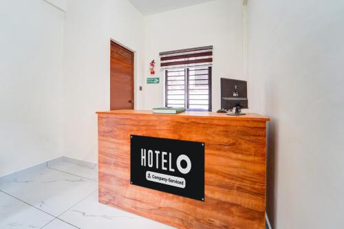 a reception desk with a hotel sign on top of it at Hotel O HMT Colony Kochi Formerly Pullans Arcade in Cochin