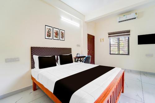 a bedroom with a large bed in a room at Hotel O HMT Colony Kochi Formerly Pullans Arcade in Cochin