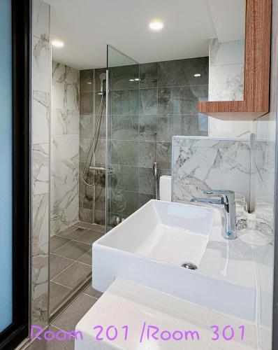 a bathroom with a white sink and a shower at 崗崗好 Gangan House in San-fen-tzu