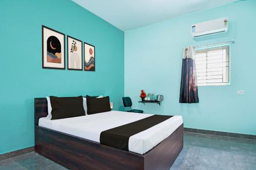 a bedroom with a large bed with blue walls at Hotel O Bhubaneshwar Near ITER College in Bhubaneshwar