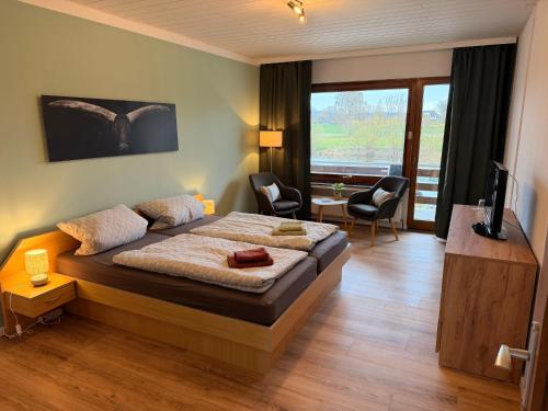 a bedroom with a bed with a desk and chairs at Campingplatz Weserterrassen Polle in Polle