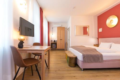 a hotel room with a bed and a desk with a computer at Hotel Wohnbar in Bamberg