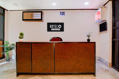 a reception desk in a room with a sign on the wall at Super Hotel O Howrah Railway Station in Kolkata