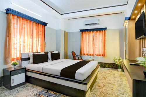 a hotel room with a bed and a television at Super Hotel O Howrah Railway Station in Kolkata
