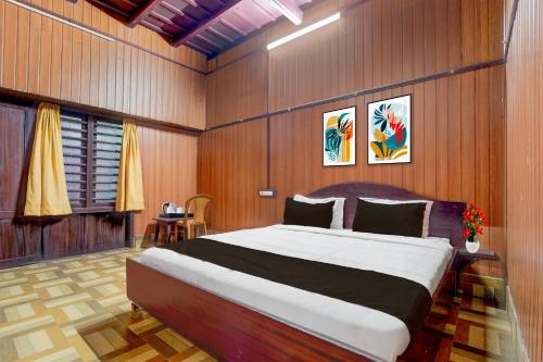 a bedroom with a large bed with wooden walls at Hotel O Kallar Vattiyar Waterfalls Munnar in Munnar