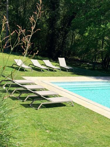 a row of lounge chairs next to a swimming pool at Quinta da Rabaçosa - Turismo Rural in Castro Daire