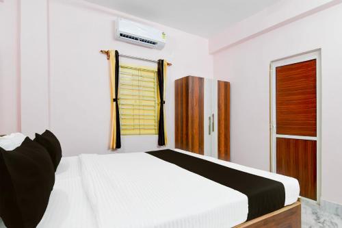 a bedroom with a white bed and a window at Hotel O Ecopark Kolkata in kolkata