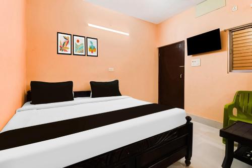 a bedroom with a large bed with orange walls at Hotel O Dakshin Dwar Formerly Radha Krishna Niwas in Puri